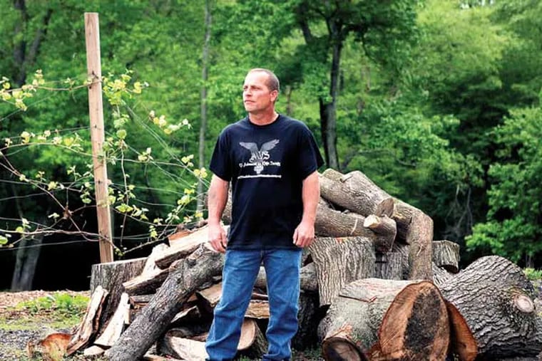 Jason Hiecke, CEO and founder of the Advanced White Society, stands in his backyard in Burlington County. The wood pile will be used in a bonfire during a meet-and-greet barbecue. ( MICHAEL S. WIRTZ / Staff Photographer )