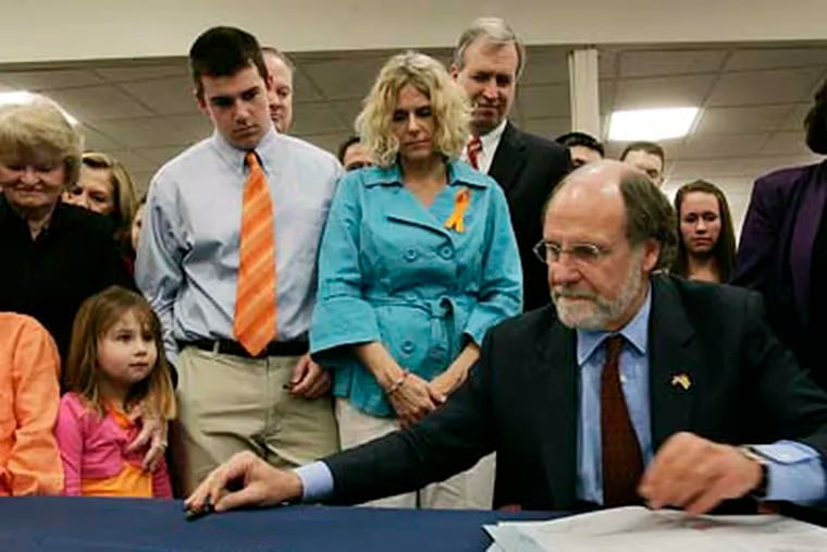 New Jersey Gov. Jon S. Corzine reaches for a pen as he signs a bill known as Kyleigh's Law. The first-in-the-nation law will require new drivers ages 21 and younger to display identifying decals on their vehicles. (AP Photo/Mel Evans)