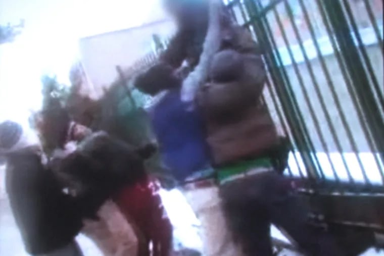 A 13-year-old is hung on a fence by his coat in Upper Darby at the hands of six bullies. This is a frame grab from raw video footage of the incident, provided by the Upper Darby Police Department.