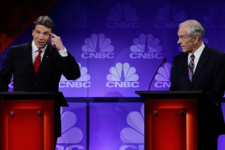 Republican presidential candidate Texas Gov. Rick Perry points his head as he speaks during a Republican Presidential Debate at Oakland University in Auburn Hills, Mich., Wednesday, Nov. 9, 2011.  At right is Rep. Ron Paul, R-Texas. (AP Photo/Paul Sancya)