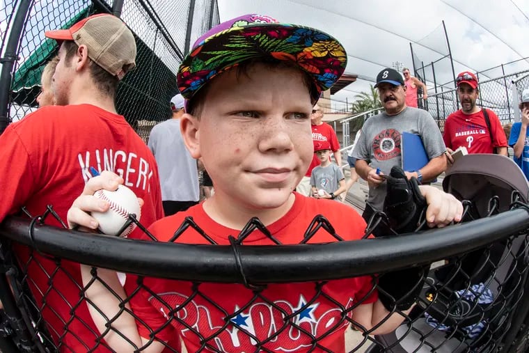 Phillies fan, Kiernan Bernardo, age 10, waits for autographs during spring training workouts at Spectrum Field in Clearwater, Fla.