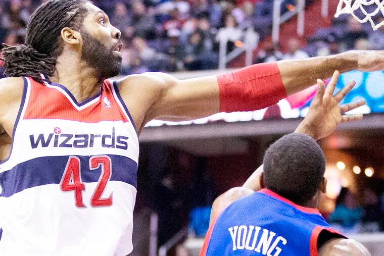 Wizards' Nene blocks a shot by Thaddeus Young.