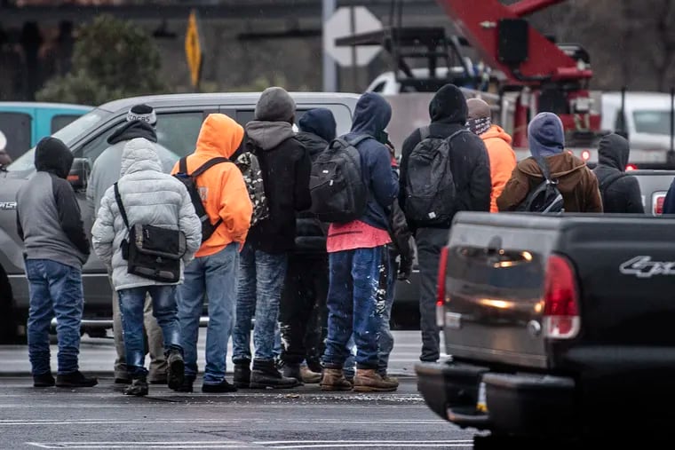 Unidentified man line up to find labor work outside a Home Depot parking lot in Philadelphia, Pa. Wednesday, December 29, 2021. Every day more than 100 men wait in the parking lot of the Home Depot looking for work. Drivers of vans and trucks pass by slowly, laden with building supplies from the nearby Home Depot. They eye the scrum of laborers to see if they can make a match.