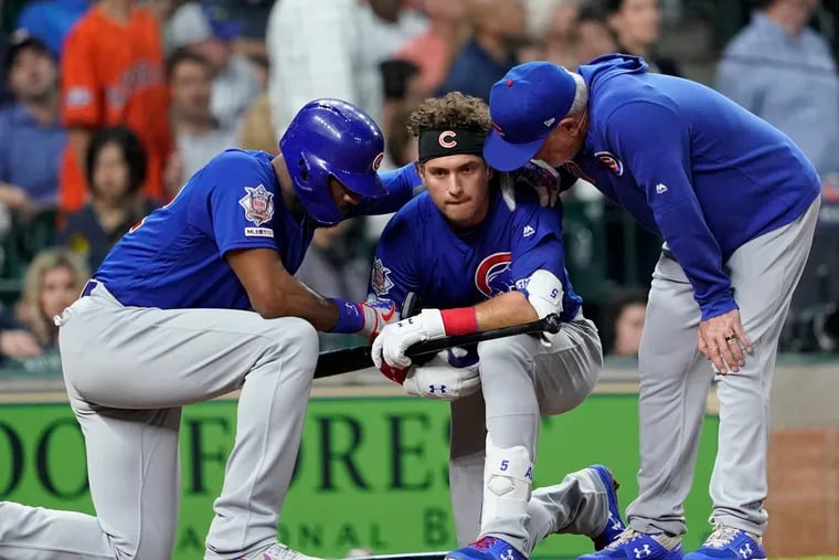 Chicago's Albert Almora Jr., center, takes a knee as Jason Heyward, left, and manager Joe Maddon, right, talk to him after he hit a foul ball that struck a child in the stands during a game against Houston on May 29.