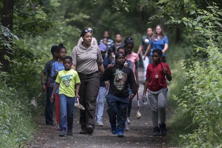 Brianna Patrick, environmental education supervisor at the Heinz Wildlife Refuge in Tinicum, PA leads a group of young campers on a nature walk.