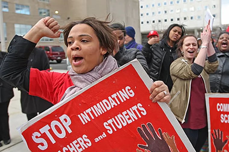 Shanee Garner, a teacher from Kensington High School, left, yields her support during a protest rally in front of the school district building Friday afternoon. (Michael Bryant / Staff Photographer)