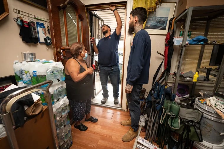 Homeowner Juana Benitez, left, and technicians Nate Melendez, back center, and Nicoles Menendez, right, talk about the weatherization improvements they will be making at her Kensington home. The technicians work for the Energy Coordinating Agency, a nonprofit.