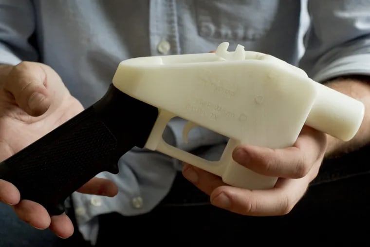 In this May 10, 2013, file photo, Cody Wilson holds what he calls a Liberator pistol that was completely made on a 3D-printer at his home in Austin, Texas.