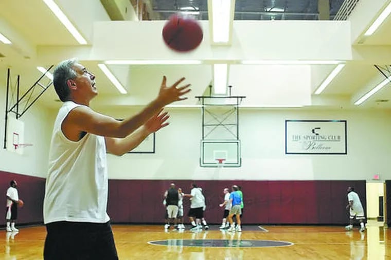 Waiting to get back on the court, John Branigan, 57, of Voorhees, warms up at the Sporting Club.