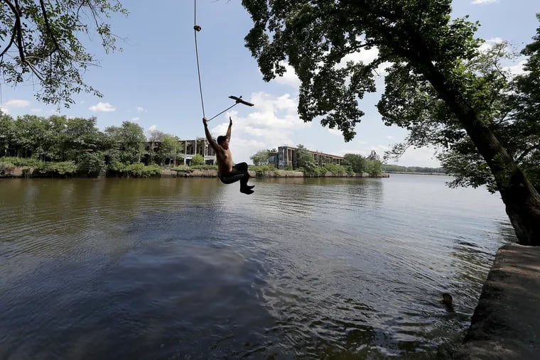 Jonathan Rodriguez, 14, of Philadelphia, jumps into the Delaware River from a rope swing near Graffiti Pier in Philadelphia, PA on August 9, 2019.