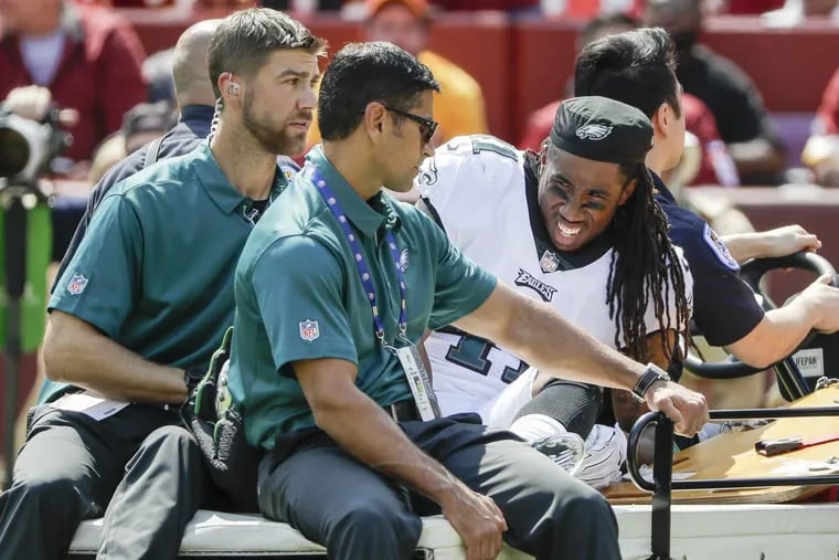 Eagles cornerback Ronald Darby (right) gets carted off the field Sunday.
