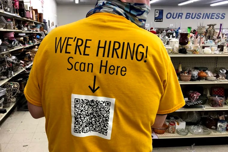An employee at the Goodwill Store in Hammonton wears a job application QR code on the back of his store uniform in May.
