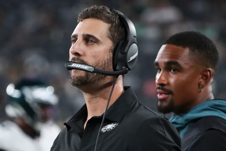Eagles quarterback Jalen Hurts standing behind head coach Nick Sirianni on the sideline at MetLife Stadium in East Rutherford, N.J., on Aug. 27.