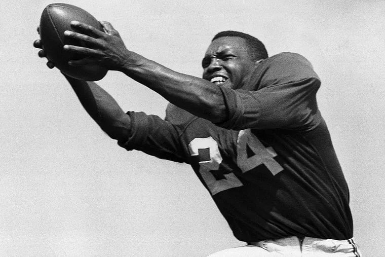 FILE - In this July 30, 1953, file photo, veteran halfback Wally Triplett of Penn State, a Cheltenham High School graduate, poses in action during his second year with Chicago Cardinals and fourth year in the National Football League. Triplett and a teammate broke the color barrier at the Cotton Bowl in 1948, and Penn State players will wear a helmet decal honoring him in Saturday's game against Memphis. (AP Photo/File)