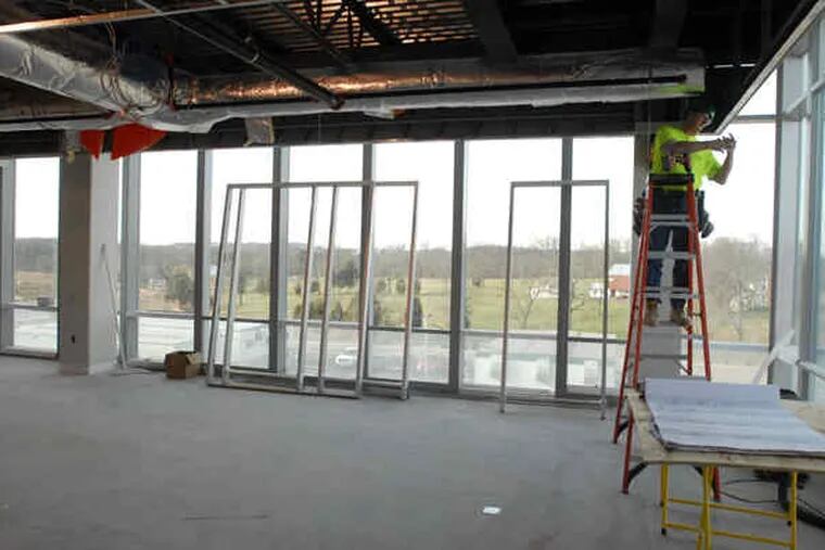 A worker, above, in the office building of the Almac North American Headquarters in Souderton. Work should be completed by August, with the new site accommodating 800 workers and replacing Almac's Pennsylvania operations in Audubon and Yardley.