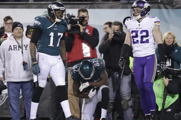 Vikings safety Harrison Smith watches as Eagles’ Torrey Smith (center) takes a knee after scoring a third-quarter touchdown and Alshon Jeffery joins in the celebration.