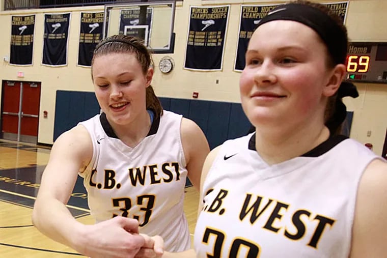 Nicole Munger, left, and Corrine Godshall of Central Bucks West pound fists as the walk off the court after their victory over Downingtown East in the District 1 AAAA girls' semifinal at Council Rock South on Feb. 25, 2015.   (Charles Fox/Staff Photographer)