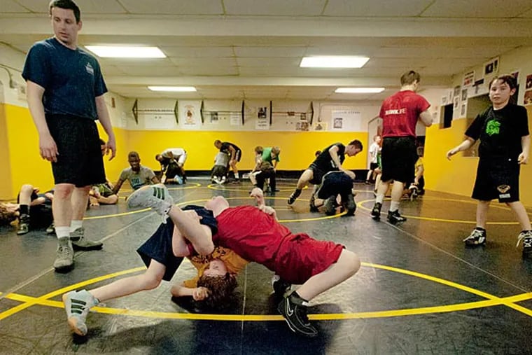 Kenny Peipher, 9, (left) and Christian Butler, 8 tangle as instructor
Chris Hanlon for Beat the Streets Philadelphia, keeps an eye on the
youth wrestling program run by Rizzo Philadelphia's Police Athletic
League, Rizzo PAL, 2524 E. Clearfield St. (Ron Tarver/Staff
Photographer)