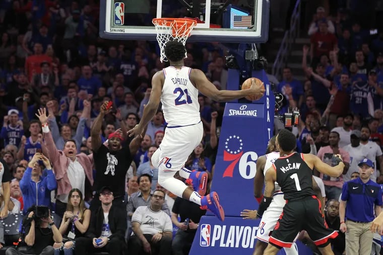 Joel Embiid of the Sixers does a windmill dunk against the Raptors during the 4th quarter of their NBA playoff game at the Wells Fargo Center on May 2, 2019.