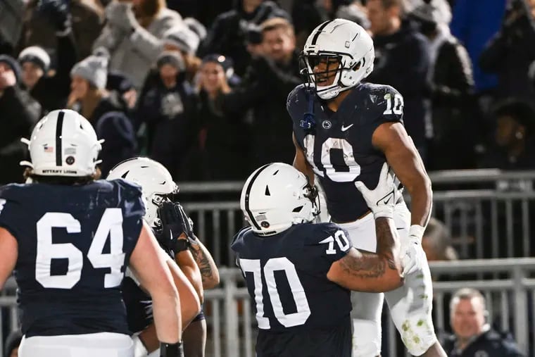 Penn State running back Nicholas Singleton is lifted by offensive lineman Juice Scruggs after scoring a touchdown against Michigan State on  Nov. 26, 2022.