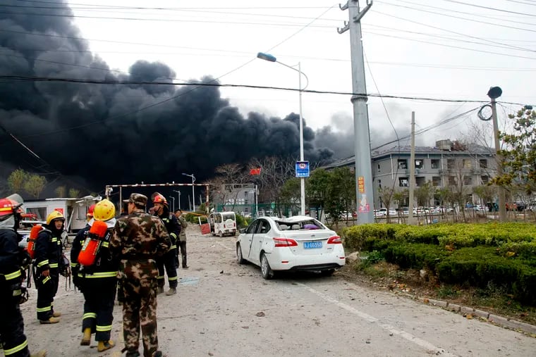 In this Thursday, March 21, 2019, photo, rescuers walk near the site of a factory explosion in a chemical industrial park in Xiangshui County of Yancheng in eastern China's Jiangsu province. (Chinatopix via AP)
