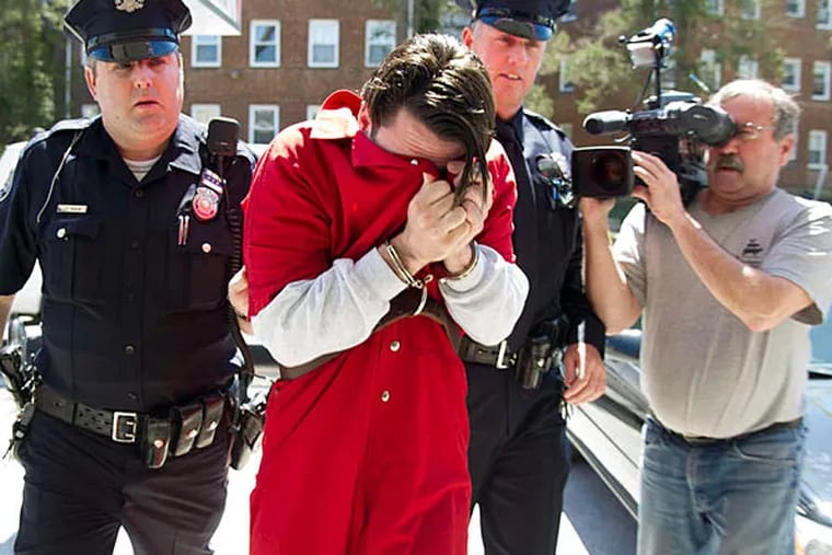 Neil Scott covers his face as he is led into a Montgomery County court yesterday. He has been in custody since February on other charges. (Clem Murray/Staff)