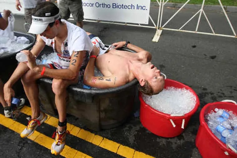 Professional competitors Rich Swor (left) and Ryan Kelly sought comfort on and in a large ice chest. Humidity was soaring and temperatures nearing 90 when the first of the pros were finishing their run about 8:45 a.m.