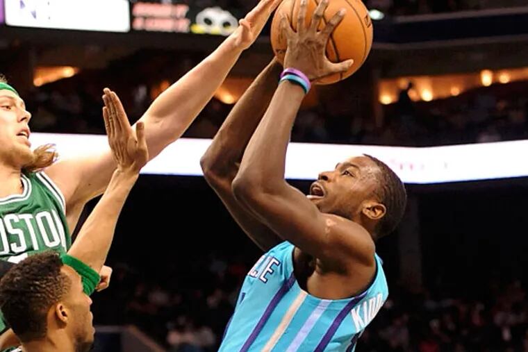 Charlotte Hornets forward Michael Kidd-Gilchrist (14) drives to the basket and shoots as he is defended by Boston Celtics center forward Kelly Olynyk (41) and guard forward Evan Turner (11) during the first half of the game at Time Warner Cable Arena. (Sam Sharpe/USA TODAY Sports)