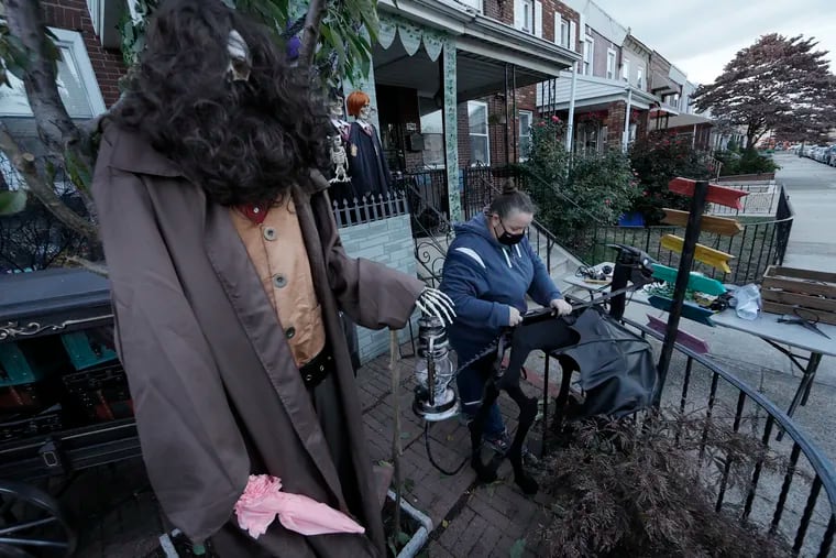 Kelli Leemon fixes the thestral decoration that is part of her house transformation for Halloween in South Philly.