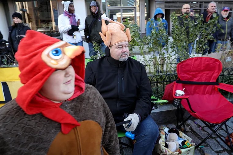 Charlie, 12, left, and his dad, Mark Strzelecki, dress the part while watching the 6ABC Dunkin’ Thanksgiving Day Parade in 2019. The Allentown family had been coming to the parade for 13 years. There won’t be a Thanksgiving Day parade in Philadelphia this year.