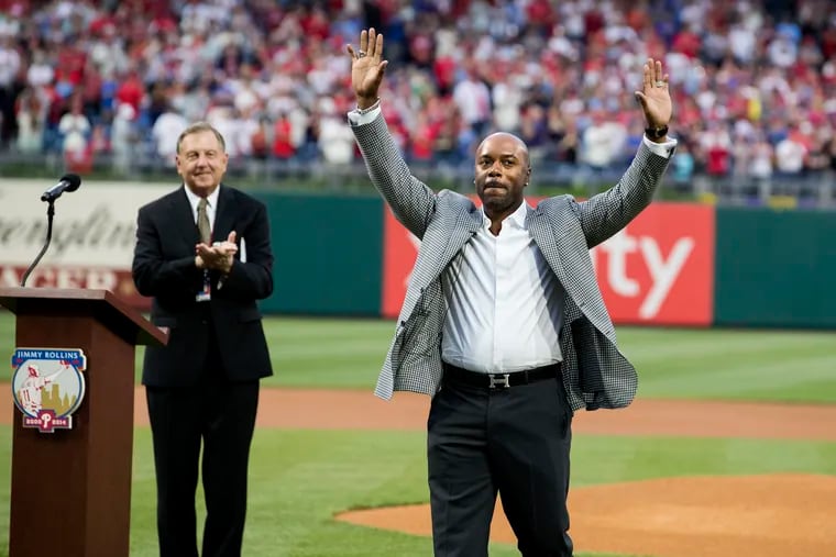 Jimmy Rollins was honored before the game between the Phillies and Nationals on Saturday and acknowledged the crowd as Dan Baker, left, looked on.