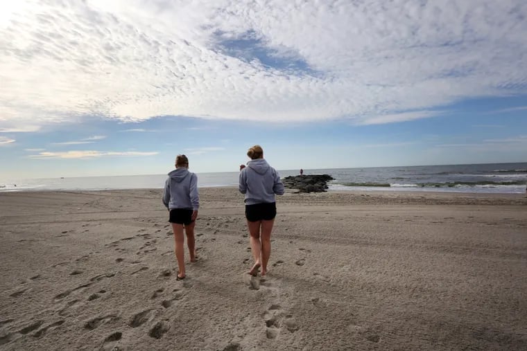 Katie McShane and her daughter, Sadie, of Gloucester City, prepare to release a container with the ashes of Eric Van Horn in the ocean, in Ocean City, last month.