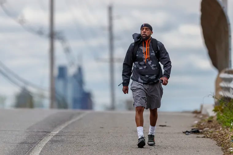 Keith Benson, the head of the Camden Education Association, walks along River Road in Pennsauken on his way to Beverly, N.J., for the first leg of his three-day walk to Trenton from Camden, to protest budget cuts that will shut several schools and possibly cause up to 200 layoffs.