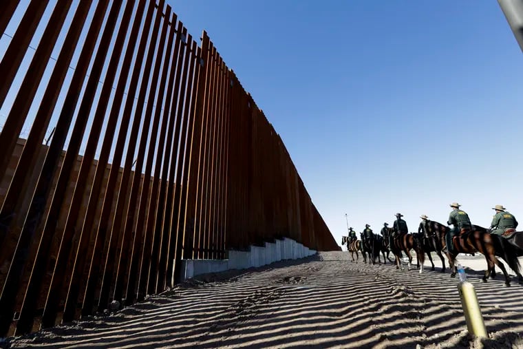 Mounted Border Patrol agents ride along a newly fortified border structure in Calexico, Calif., in 2018, shortly before President Trump was to visit and tour this portion of barrier.