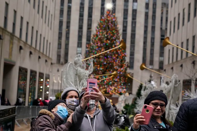 People taking pictures of themselves in front of the Rockefeller Center tree in New York on Christmas Day 2020.
