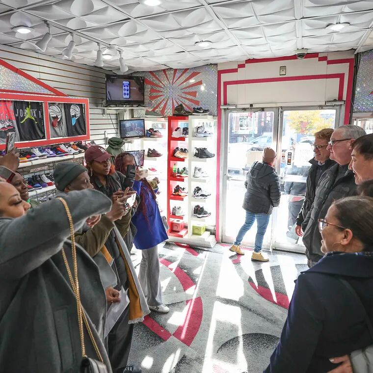 Yong Lee, owner of Young's Sneaker City on West Girard Avenue in Brewerytown, poses for photos with then-Mayor Jim Kenney during a November 2023 visit to his store.