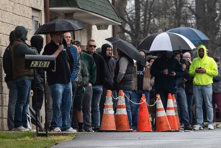 People wait in line to enter gun seller Tanner's Sports Center in Jamison, Pa. Gun sales have surged during the pandemic.