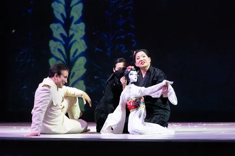 In Opera Philadelphia's production of Puccini's 'Madame Butterfly,' Cio Cio San (Karen Chia-Ling Ho) with puppet; Pinkerton (Anthony Ciaramitaro); and puppet artist Hua Hua Zhang.