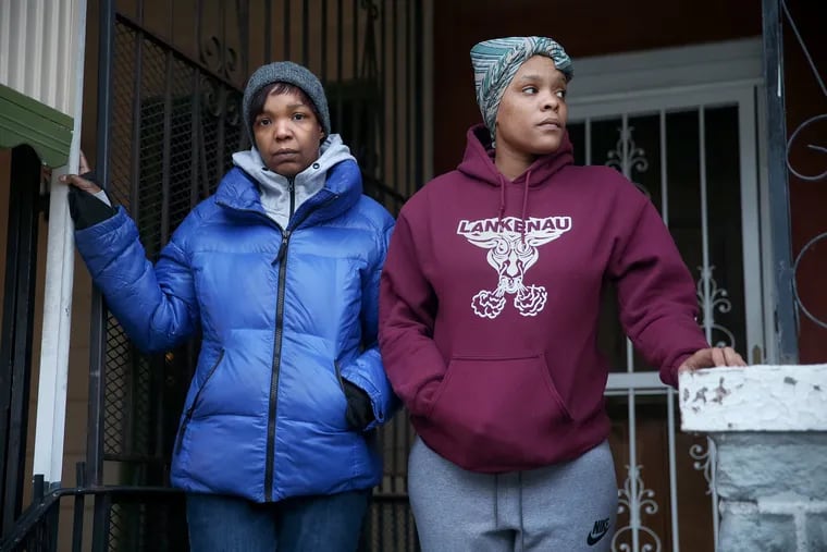 Sabrina Cooke, left, and Sierra Robinson stand for a portrait in front of the West Philadelphia home where Robinson is now staying. The two friends both lived nearly a decade in the Admiral Court apartments in West Philadelphia, but were forced out after the landlord, who was unlicensed and could not legally evict tenants had the doors locked Monday.