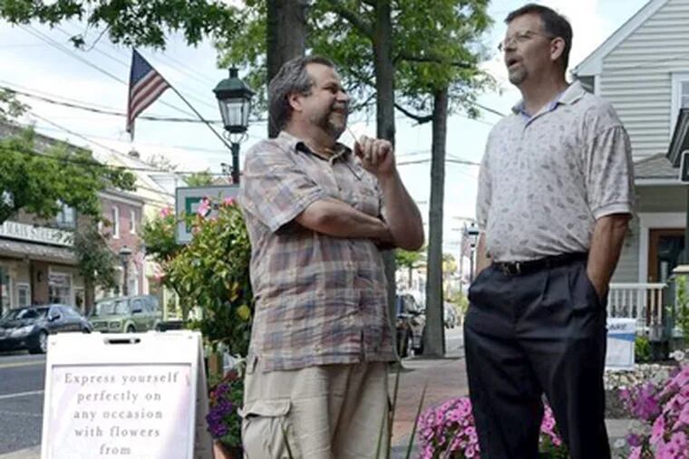 Medford Mayor Randy Pace (right) talks with Simon Iredale, who owns Medford Florist &amp; Gift Shop, as he walks along Main Street. TOM GRALISH / Staff Photographer