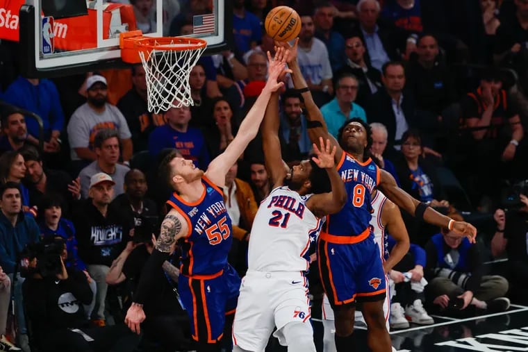 Sixers Joel Embiid is blocked by Knicks Isaiah Hartenstein, left, and DaQuan Jeffries during the first quarter of Game 5 in New York, Tuesday, April 30, 2024.