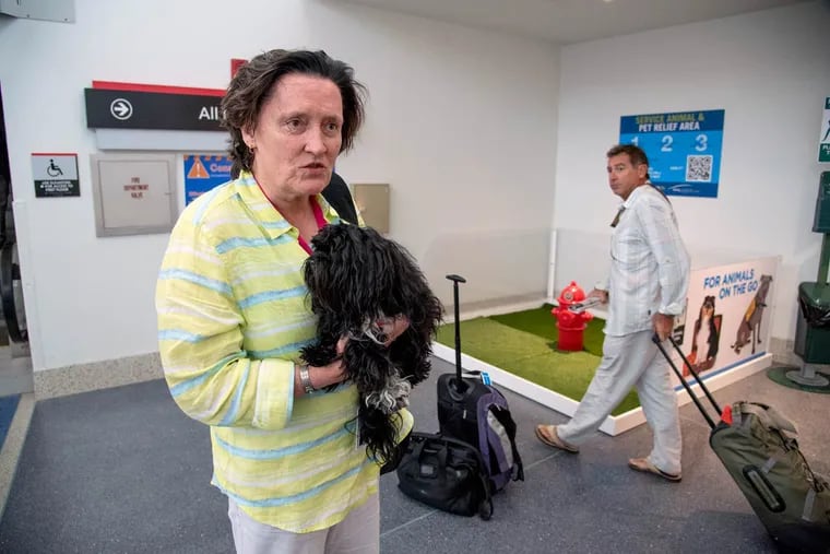 Jennet Inglis, of Staunton, Va., holds her service dog Sophia Moon as they check out the new animal relief area in Terminal F at the Philadelphia International Airport on Aug. 8, 2016.