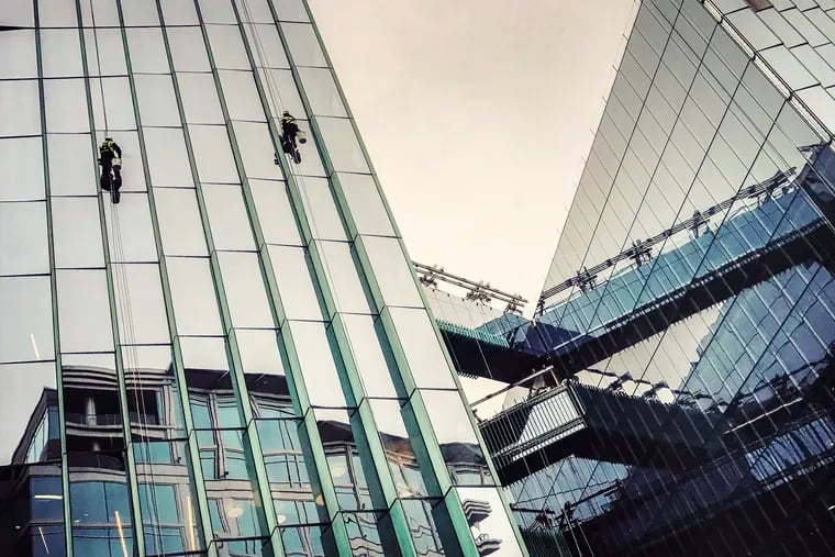Workers clean the glass sides of the Fannie Mae headquarters in Washington. Washington Post photo by Bill O'Leary