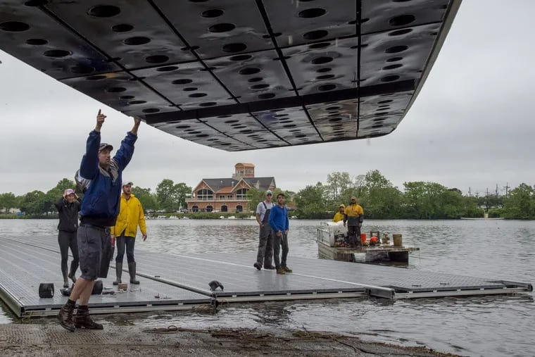 Workers unload docks into the Cooper River after transporting them from the Schuylkill on Wednesday. The Stotesbury Cup was moved from Philadelphia to South Jersey due to river conditions.