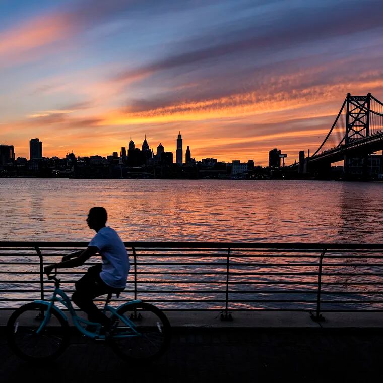The sun sets behind the Philadelphia skyline as seen from the Camden Waterfront.