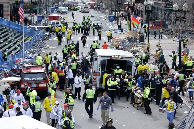 Medical workers aid injured people at the finish line of the 2013 Boston Marathon following an explosion in Boston.