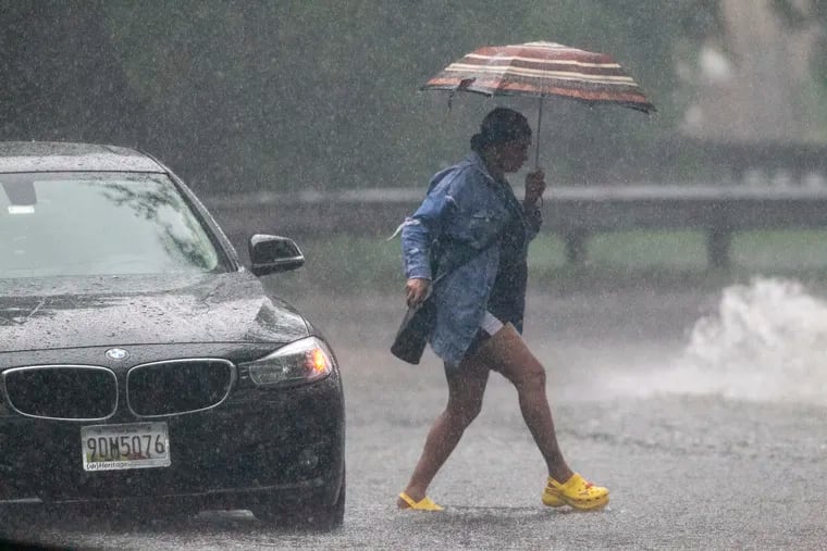 Motorist along Cobbs Creek leaves her vehicle after heavy rain and flash flooding stalled her vehicle during downpours in August 2020. Heavy rains are possible throughout the region Tuesday.
