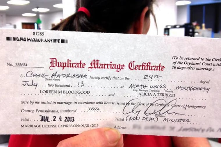 July 24, 2013 file photo: A staffer in the Montgomery County Register of Wills department, who did not want to be identified, holds up the first marriage license for a gay couple. (JESSICA PARKS / Staff)