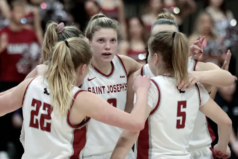 Talya Brugler (center) and the St. Joseph's Hawks improved to 23-2 with a rout of Dayton on Wednesday night. They are shown in a game on Feb. 3.