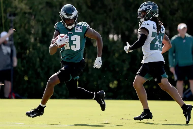 Josh Adams, left, tries to run by free safety Avonte Maddox during Eagles training camp Monday.